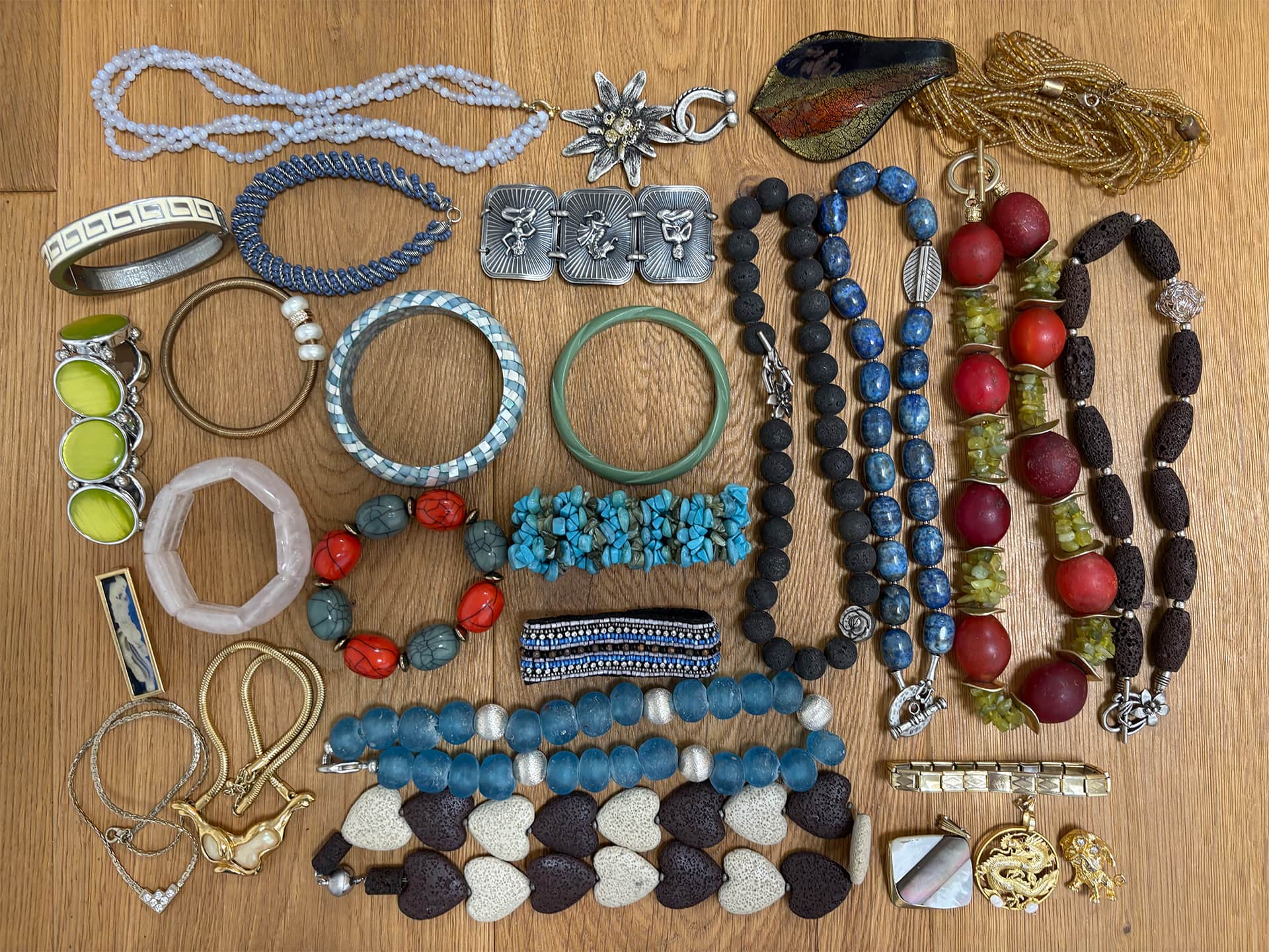 Bijoux fantaisie avec bracelets et colliers de perles sur une table en bois