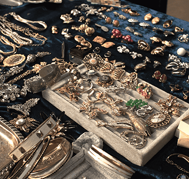 Broches vintage, boucles d’oreilles et bracelets triés sur du velours bleu