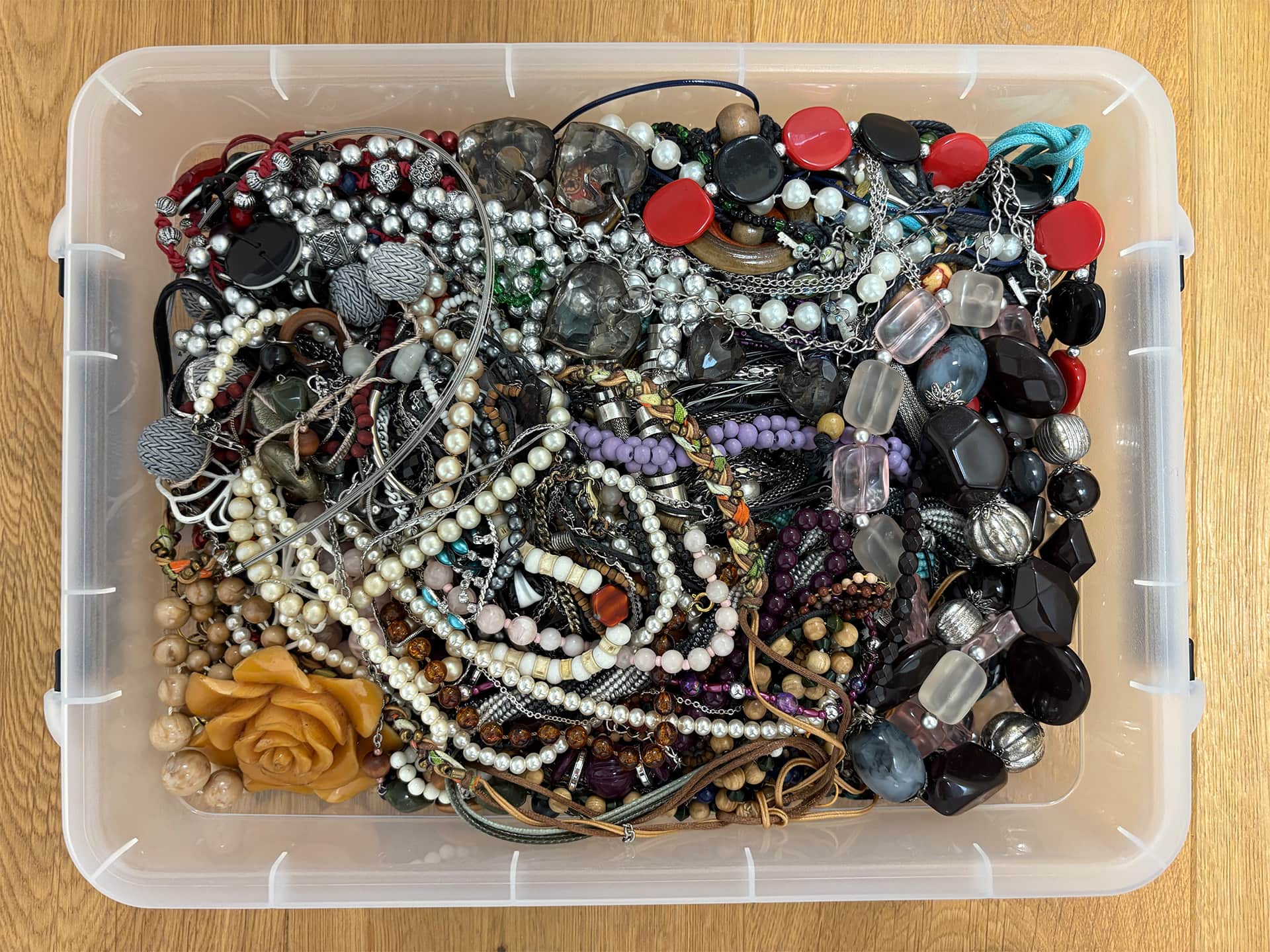 Caisse de bijoux fantaisie avec colliers de perles proposés au rachat