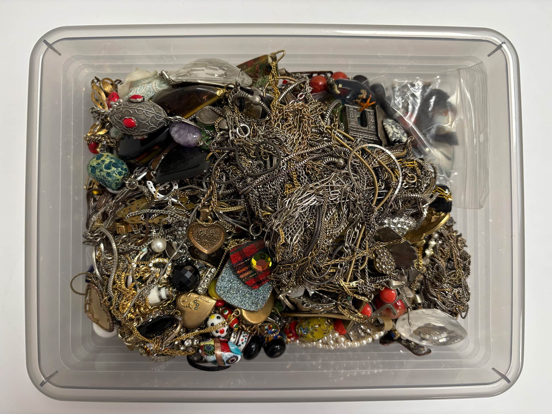 Boîte remplie de bijoux fantaisie avec colliers et pendentifs pour le rachat en ligne